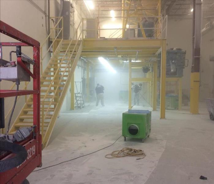 A air scrubber being utilized in conjunction with a manufacturing cleaning project.
